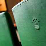 Detail of a green leather chair with the Rolex Crown embossed into the backrest
